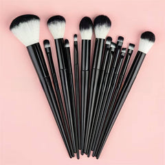 Set of black makeup brushes with white bristles on a pink background