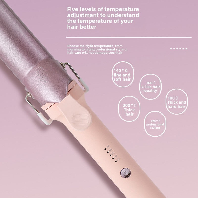 A rose gold curling iron shown diagonally on a dusty pink background with informational text and temperature circles detailing heat levels and hair types it can style.